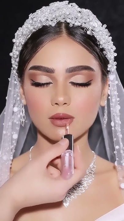 عروسة بفستان زفاف أبيض فخم تعكس الجمال والأناقة، مع نصائح للعروسة قبل الزفاف للعناية بالجمال وتجهيزات ليلة العمر."