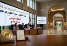 "شاشة عرض رسمية للمجلس الأعلى لتنظيم الإعلام تعرض قرار منع ظهور ضياء العوضي وسارة هادي، بجانب تفاصيل إجازة عيد الفطر 2026 في قاعة مؤتمرات حكومية مصرية."